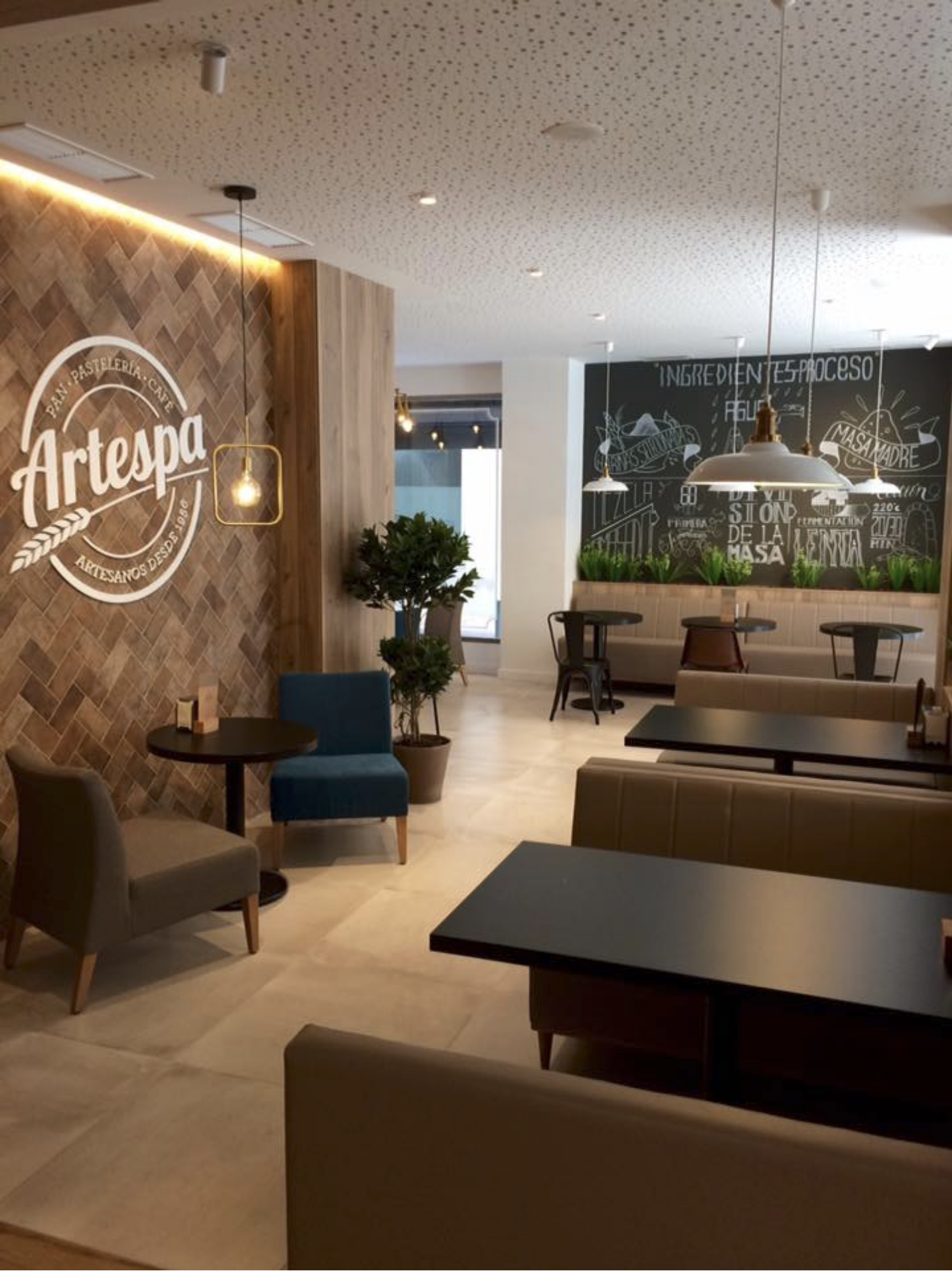 Salón interior Artespa con sofás y logo en pared